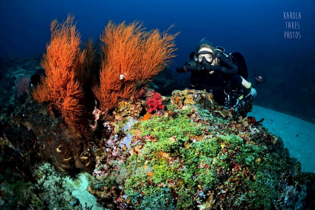 Female Technical Diver underwater with CCR Setup next to Reef.